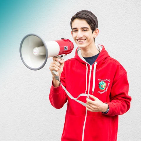 Ein Jugendrotkreuzler hält ein Megaphone in der Hand